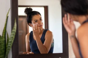 a woman applying cream on her face
