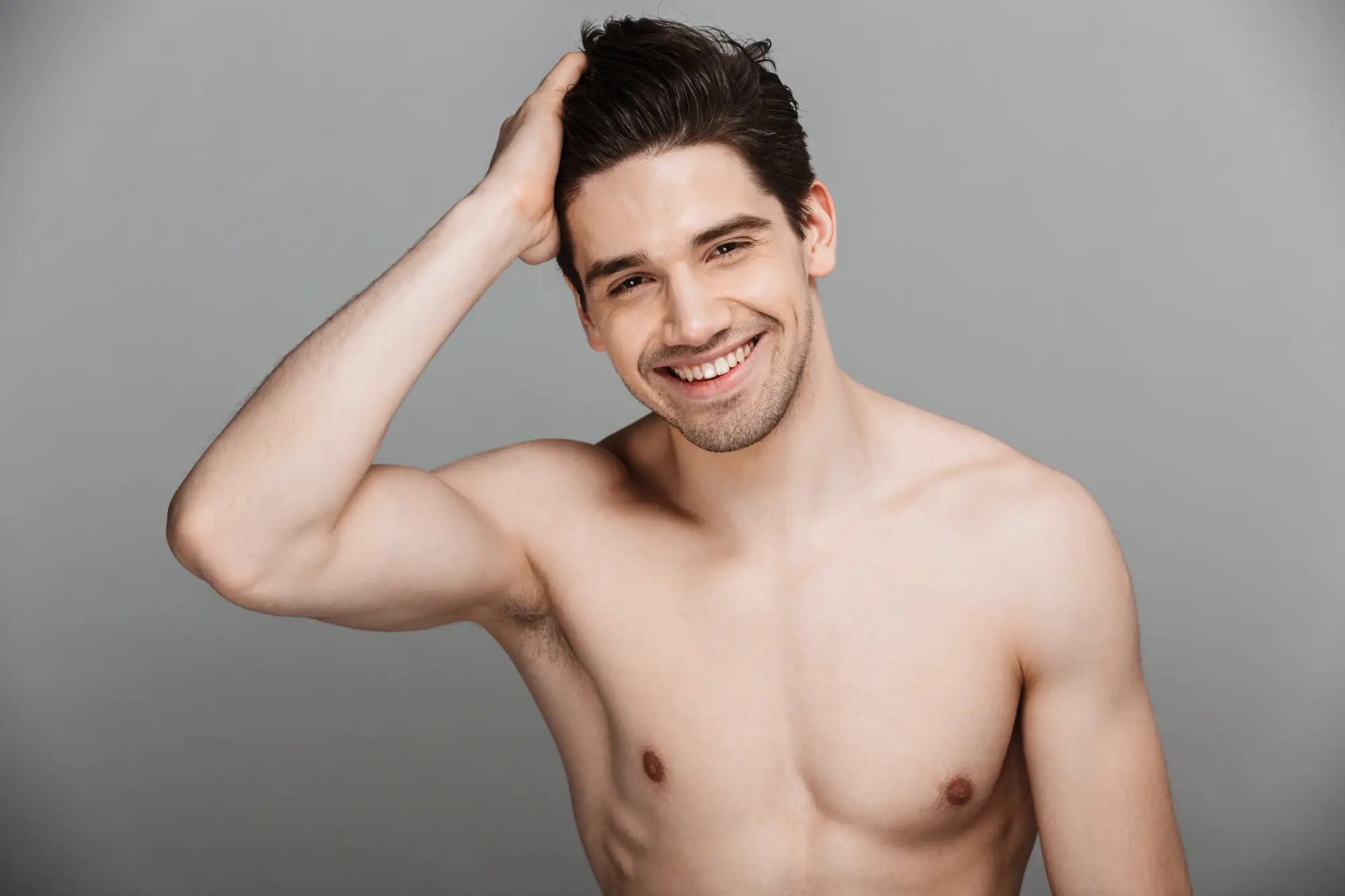 a man smiling with his hand on his head